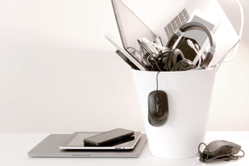 A garbage can overflowing with electronic devices