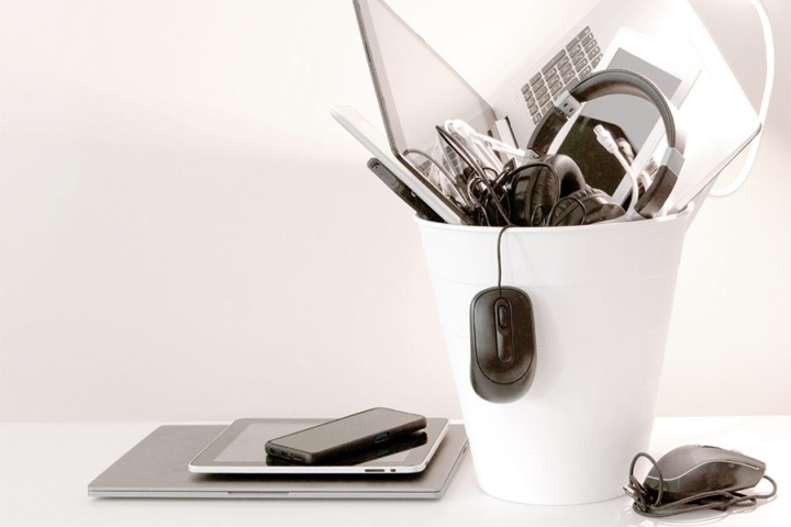 A garbage can overflowing with electronic devices