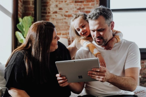 Two adults and a child looking at a tablet