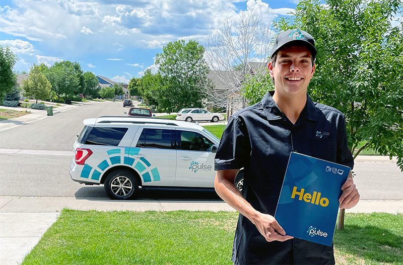 Hello - Pulse is Here A Pulse representative with a welcome folder and Pulse truck in the background