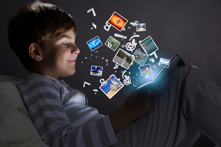 A young boy looking at a tablet.