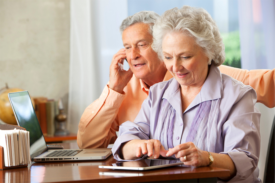 Image of a man on a phone and a woman using a tablet