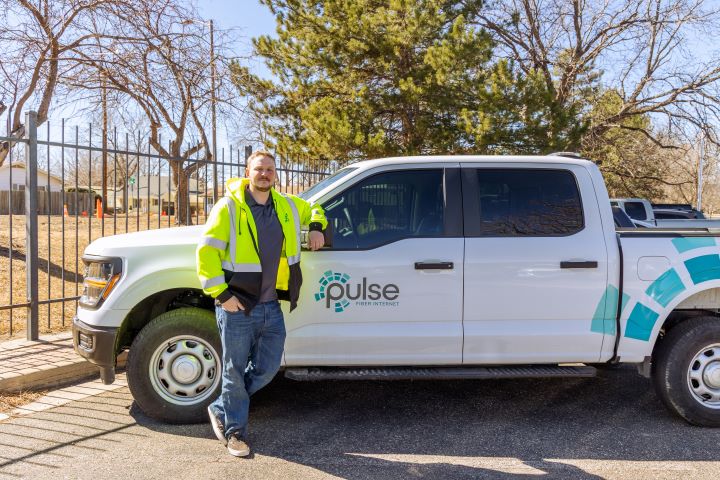 Caleb_PulseTruck-3_SM Pulse Fiber technician leaning against a Pulse Fiber truck