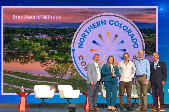Image of 5 people on a stage accepting an award. There is a screen behind that says Start Award Winner and has the Northern Colorado Community Fiber logo.