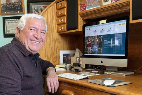 Image of a happy Pulse customer sitting at their desk with the Pulse website pulled up on a computer screen