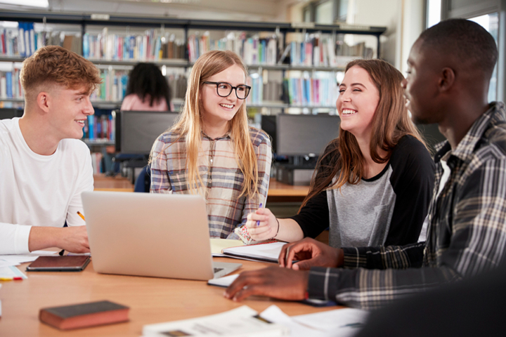 AI - Protect your high school students 2024 Photograph of high-school aged students sitting around a table. There is a laptop open on the table.