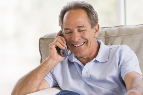 Photograph of man using a home telephone