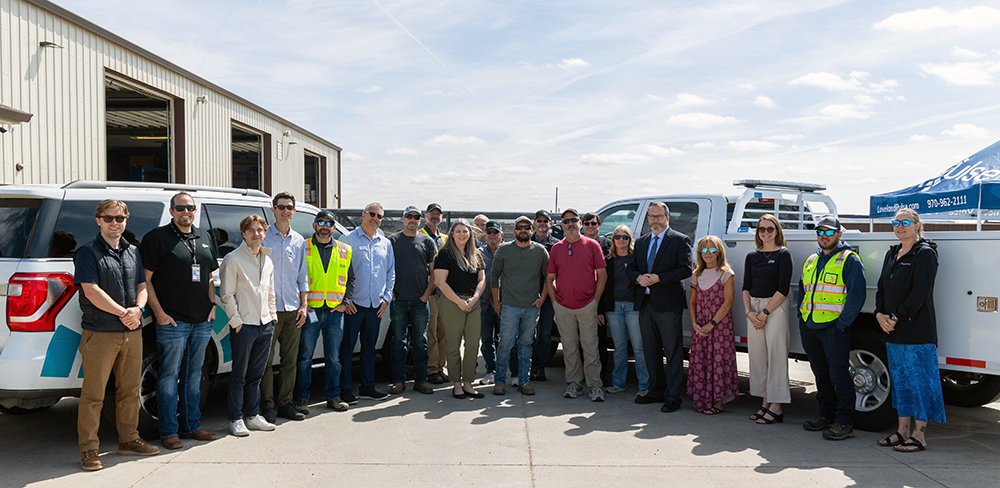 Photograph of attendees at the celebration event for Pulse Fiber lighting up Dean Contracting.