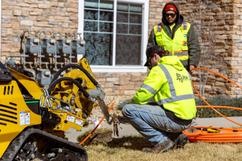 Two men installing fiber-optic cables